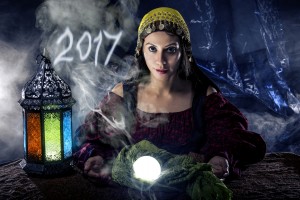 Female fortune teller doing a psychic reading with a cystal ball predicting the future of 2017. The image is an illustrative editorial of the new year.